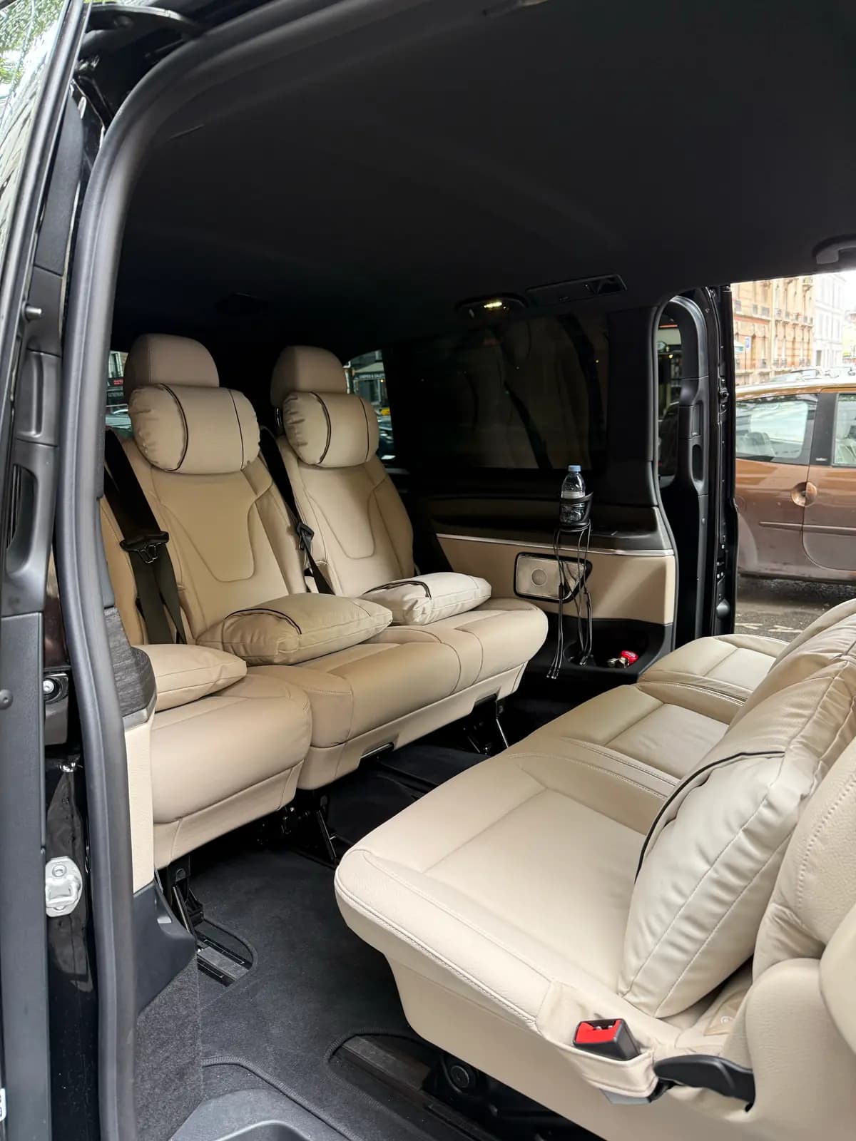 Espace passagers d'un van : sièges clairs avec appuie-tête et coussins